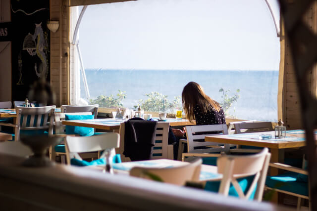 girl sat in a beach cafe