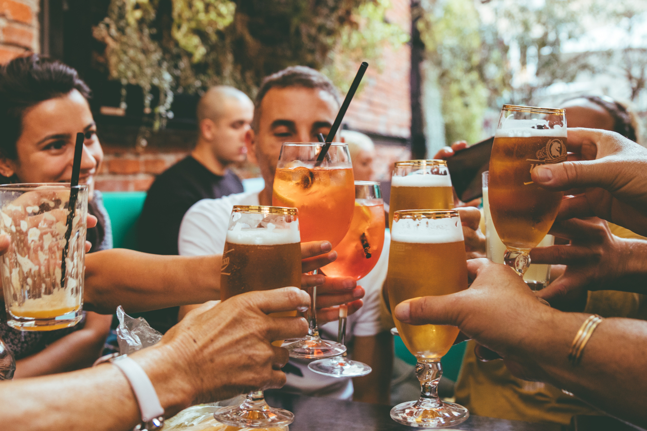 group of friends clinking drinks at the pub