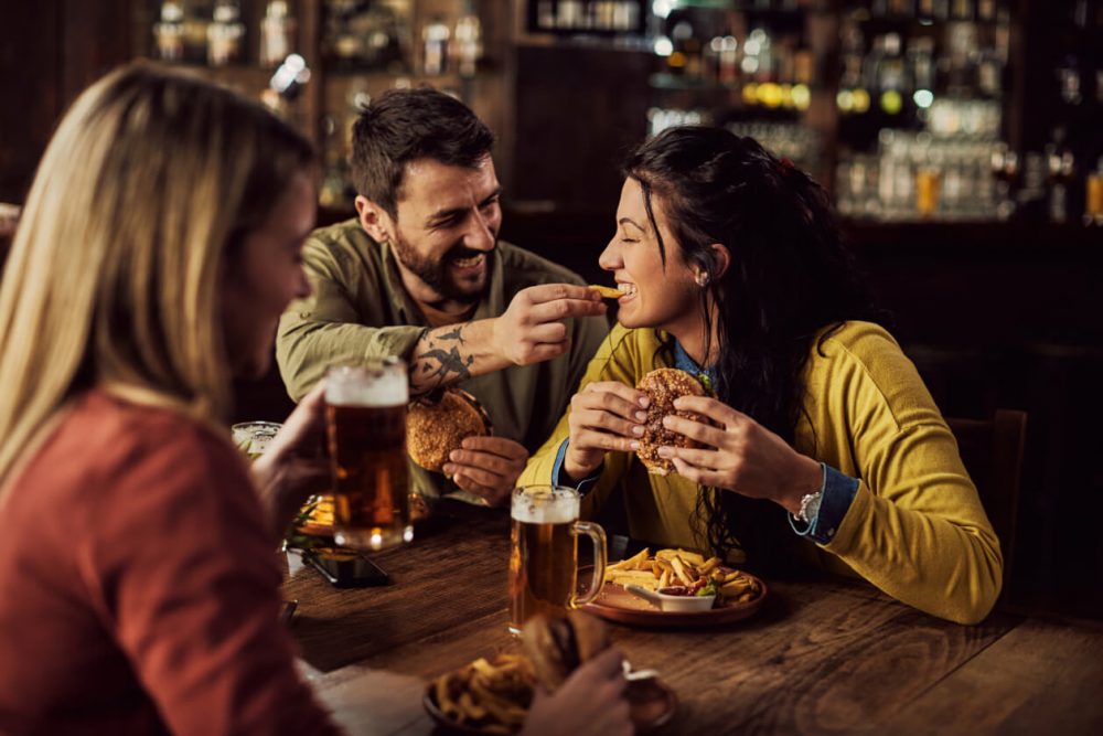 group of three people enjoying a meal at a pub