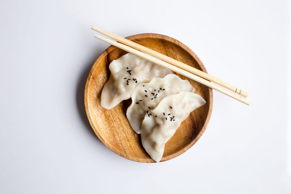 gyoza in bamboo bowl with chopsticks