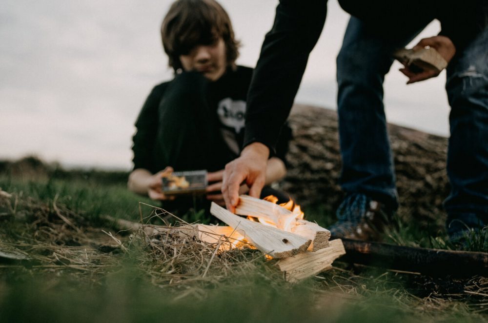 man and son lighting a fire