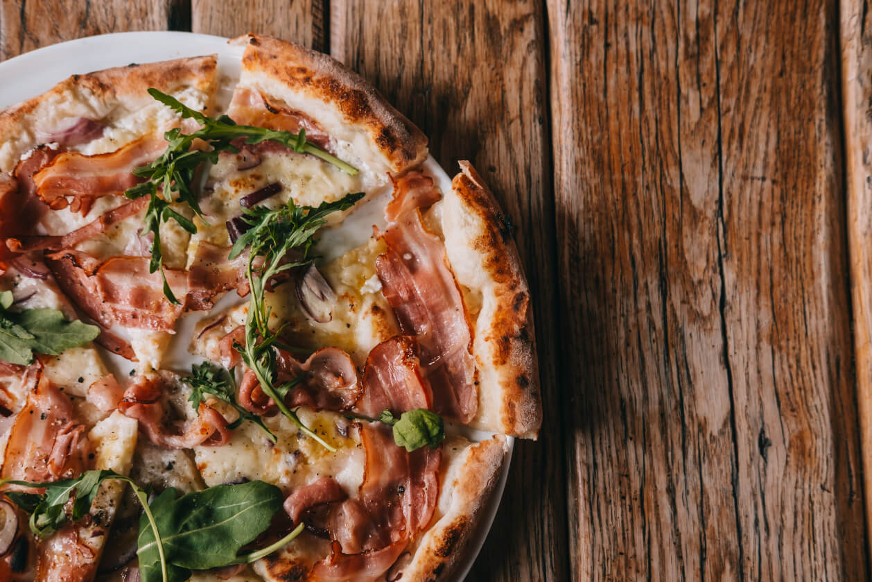 pizza with ham and rocket topping