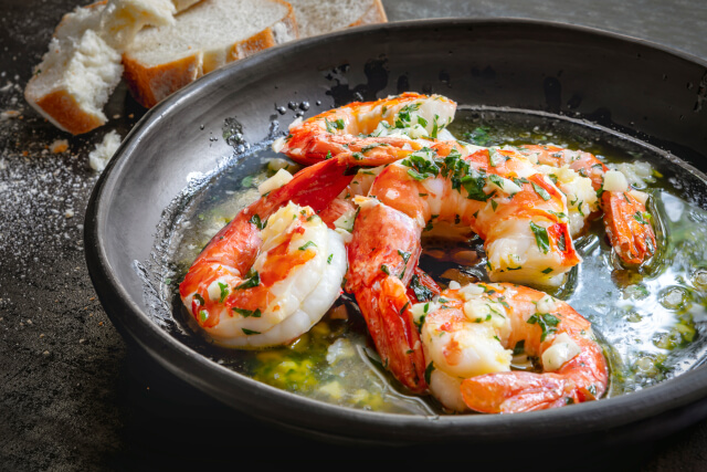 prawns in garlic butter in bowl with bread