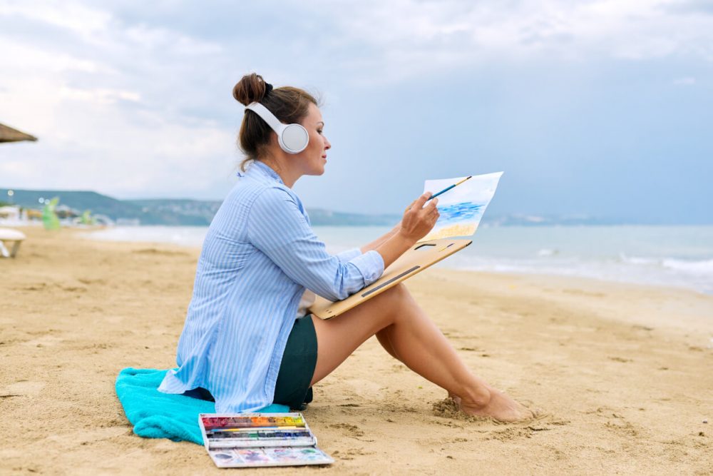 sitting on sandy beach drawing