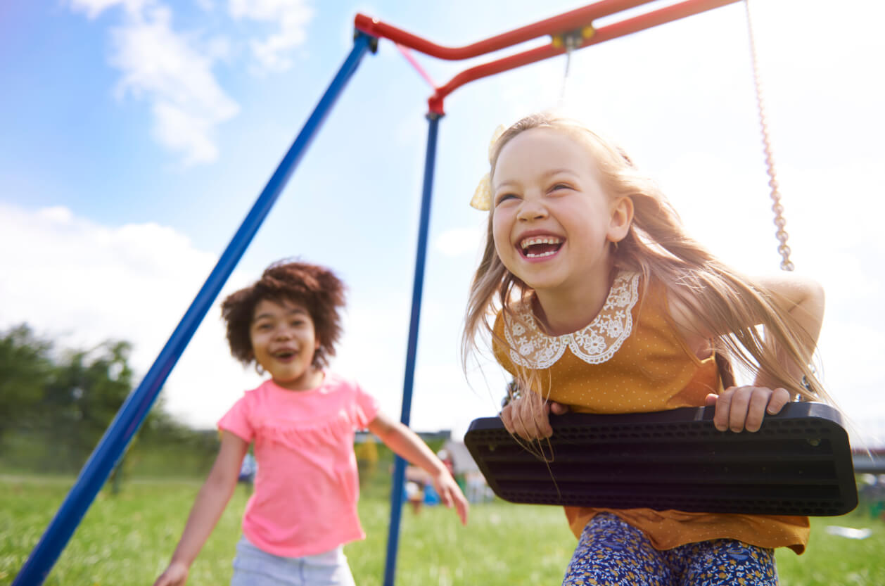 two girls playing on a swing