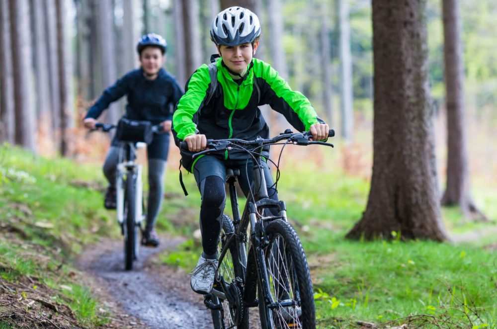 two teens biking in forest