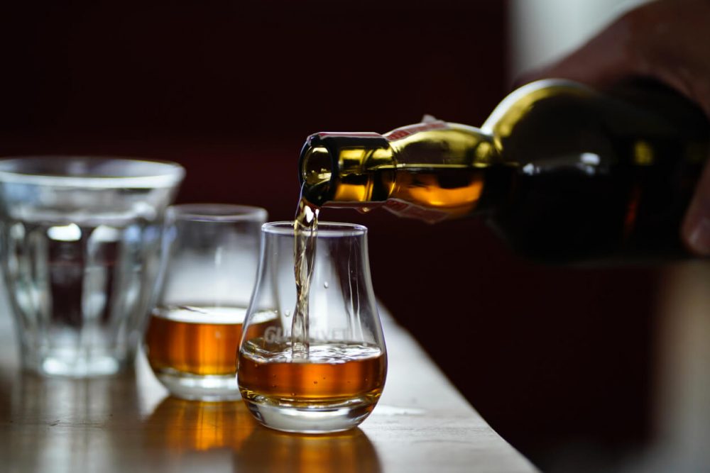 whiskey being poured into glasses