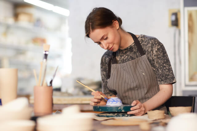 woman painting pottery