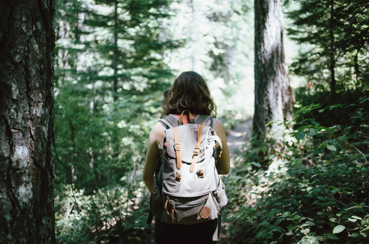 woman walking into a forest